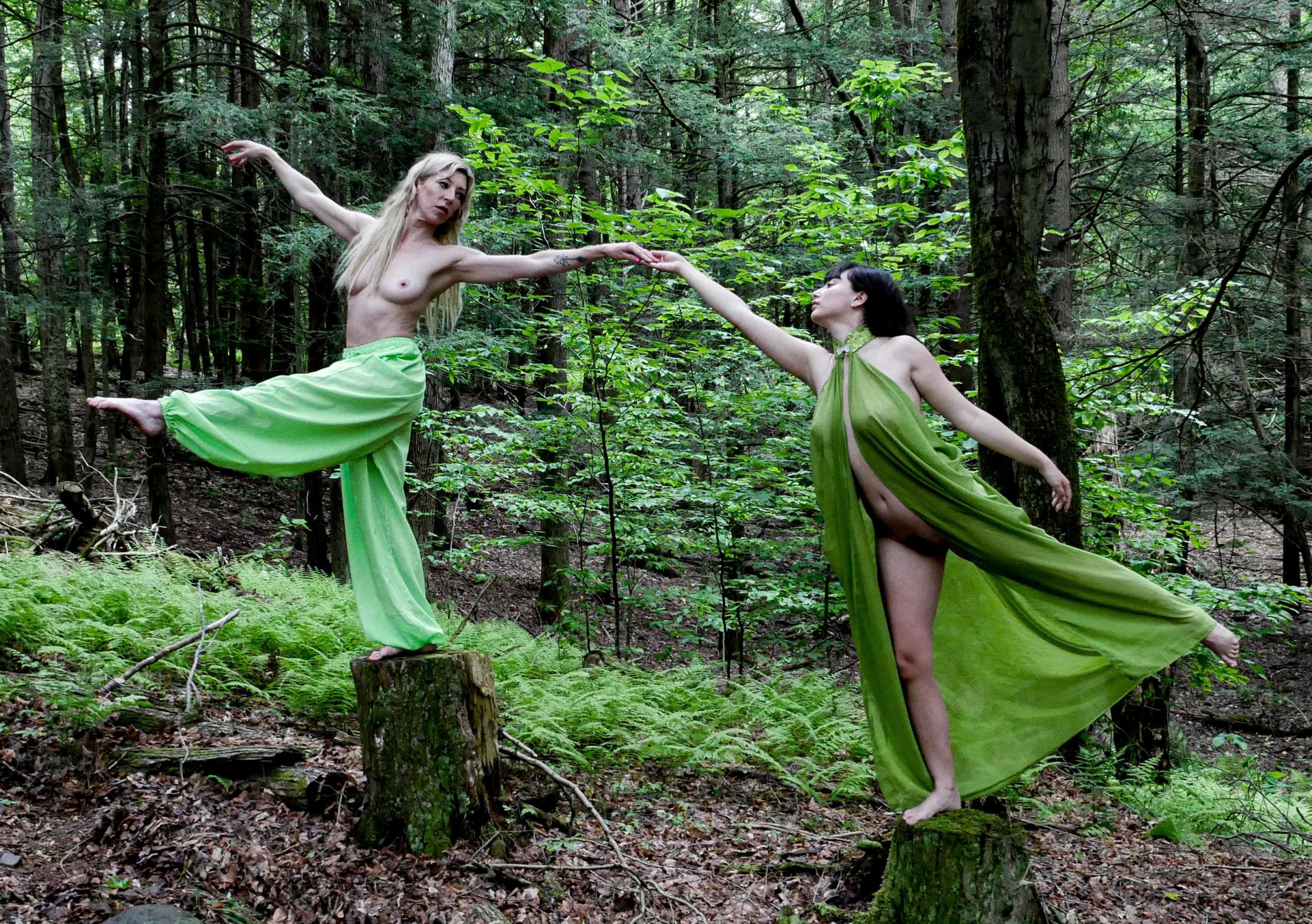 Two angels dancing on tree stumps to the music of the forest.